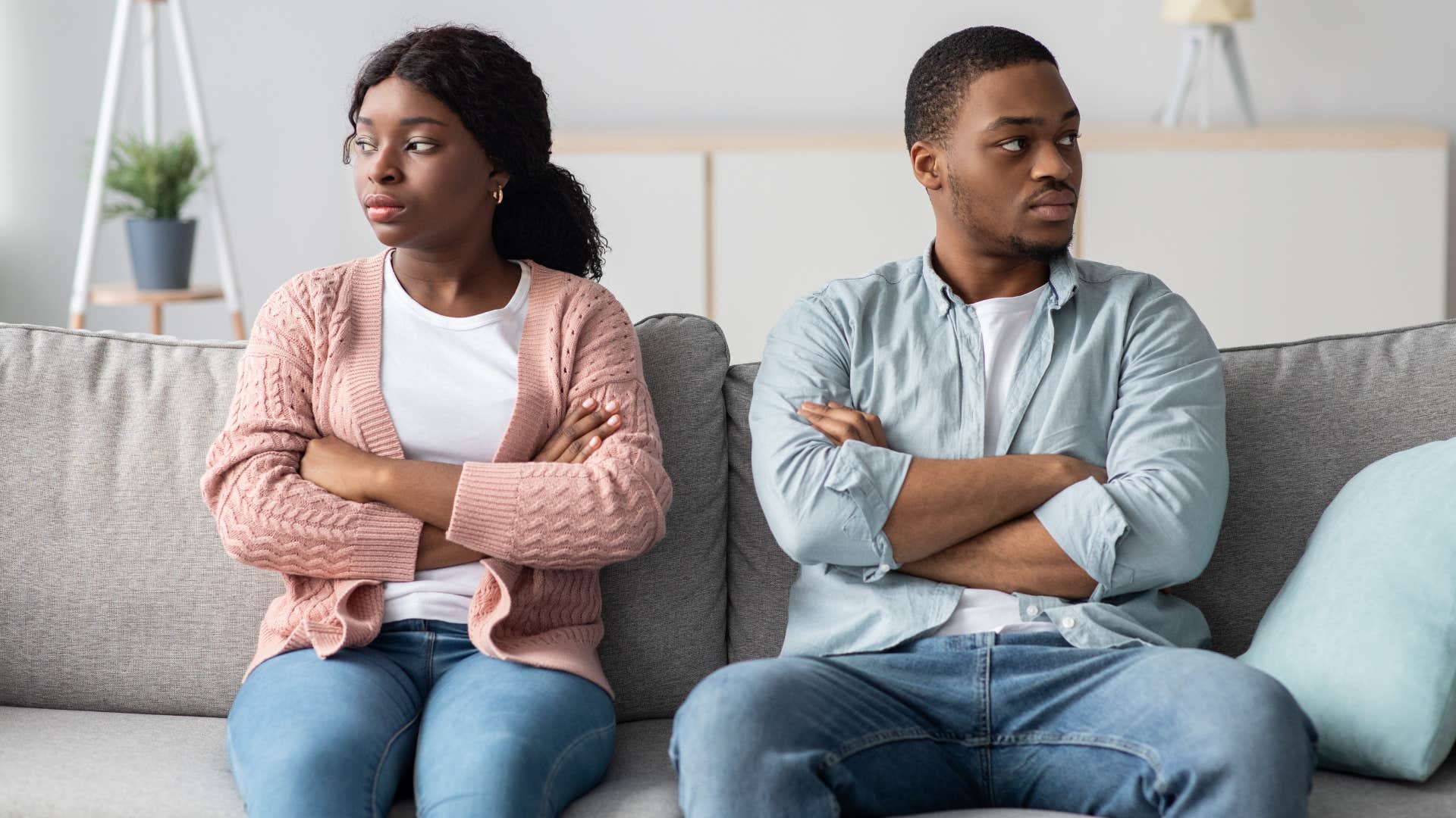Couple looking away from each other with their arms crossed.