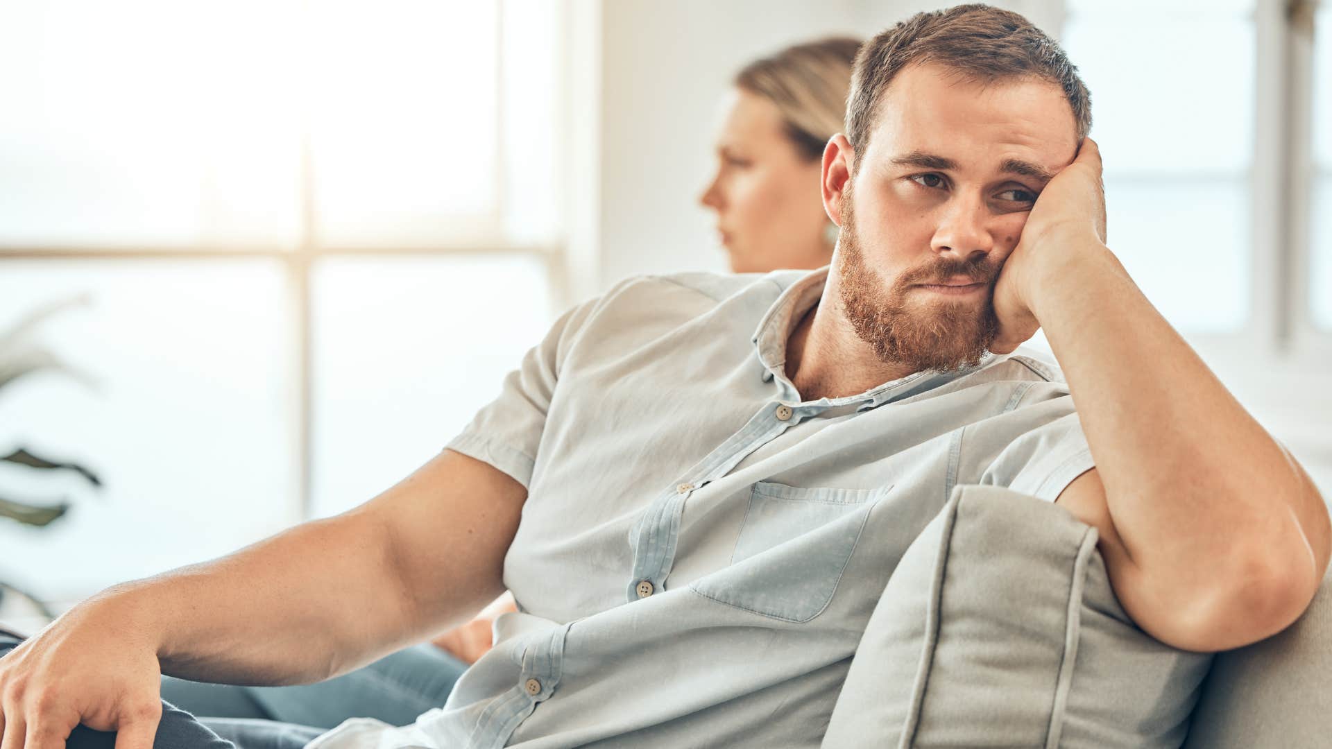 Man looking upset staring away from his partner.