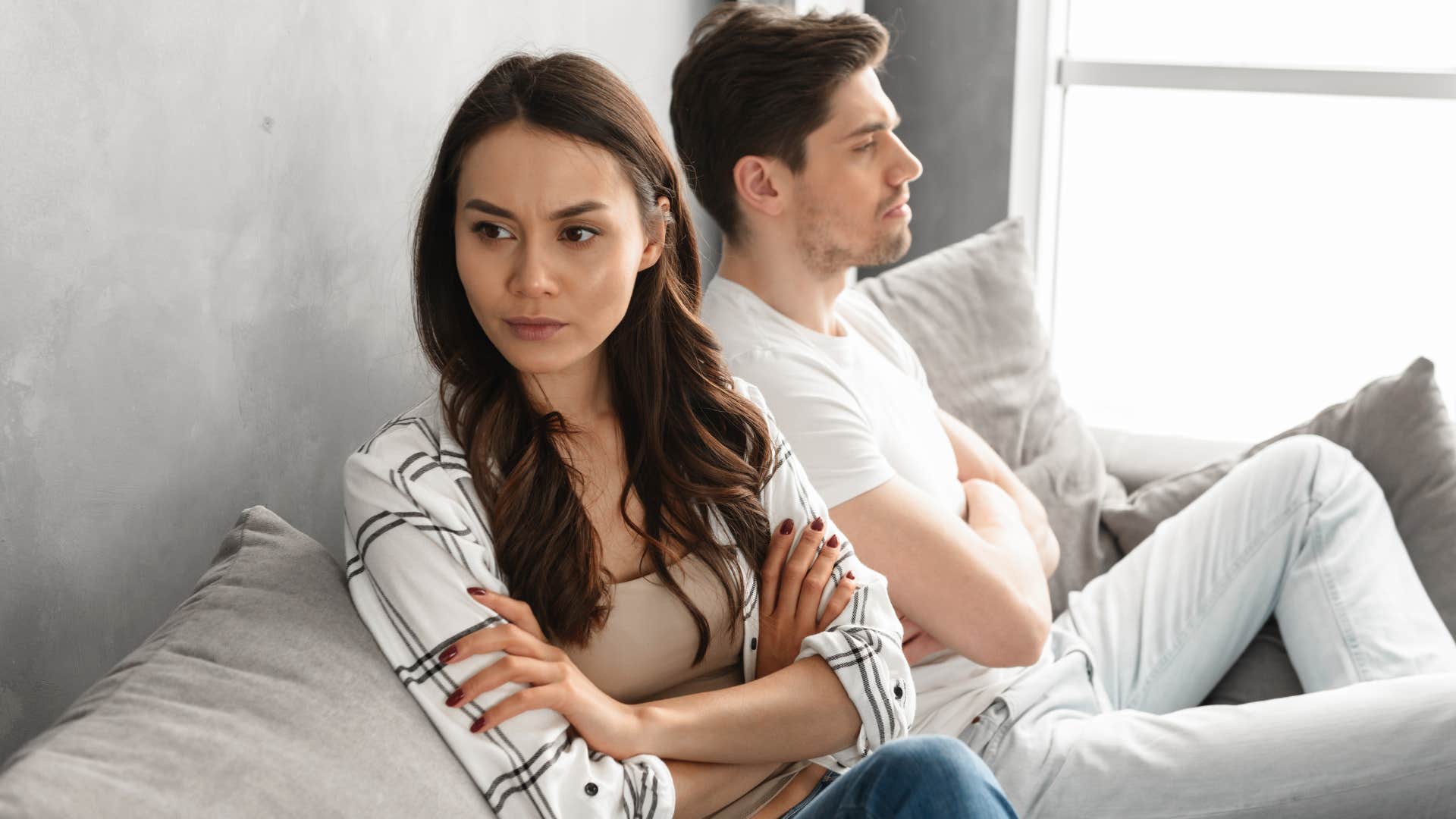 Woman looking away from her partner on the couch.