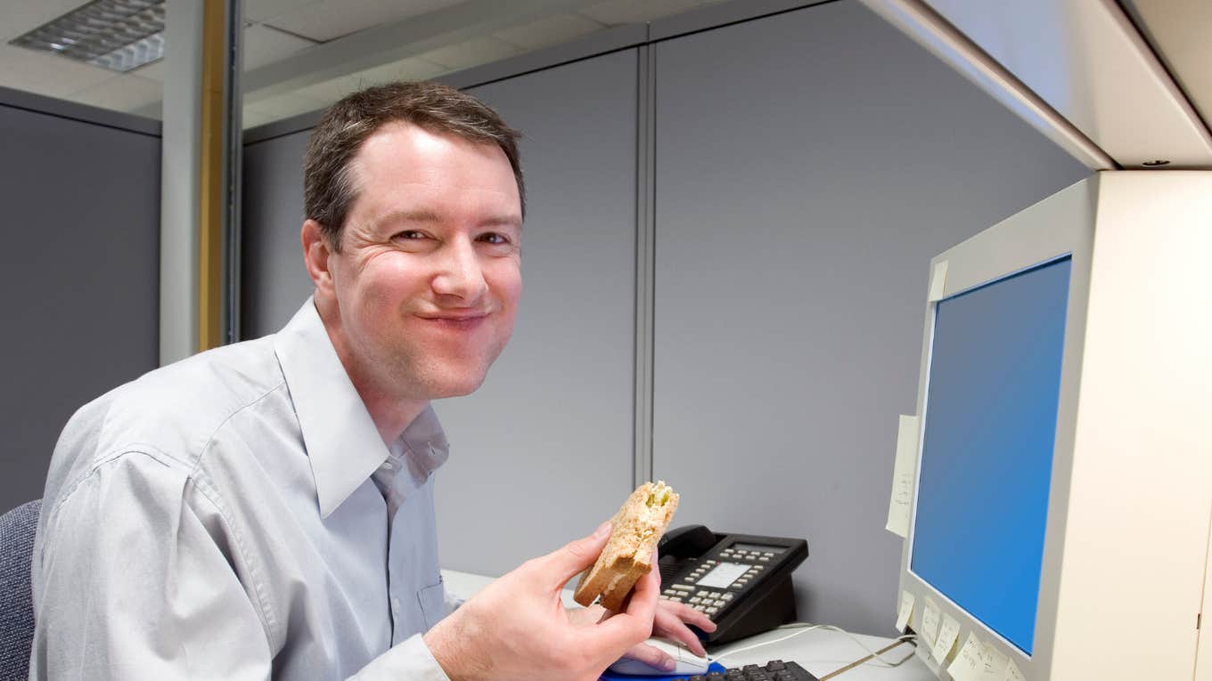Report Reveals Most Workers Skip Lunch Because They’re Too Busy man eating sandwich while working