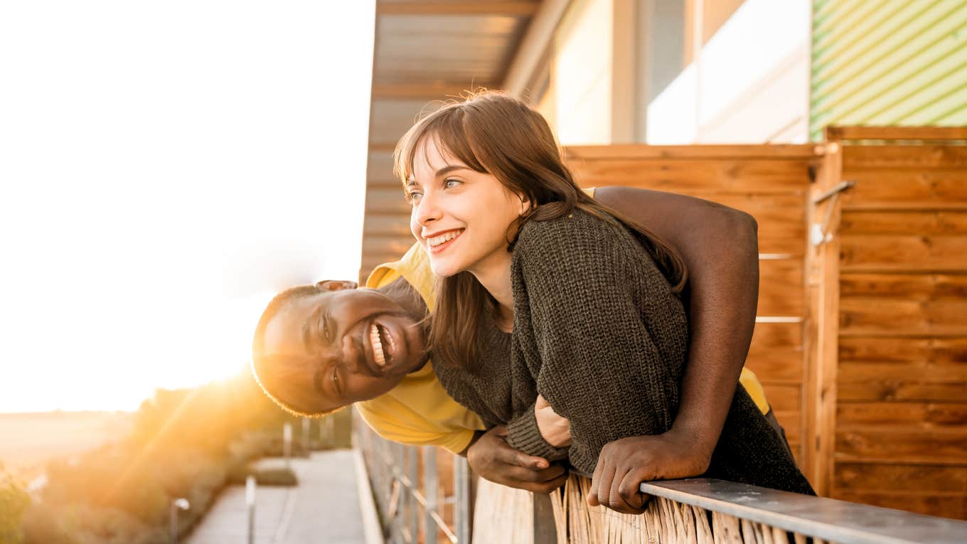 Signs A Man Will Make An Excellent Life Partner, According To Psychology Happy couple on balcony.