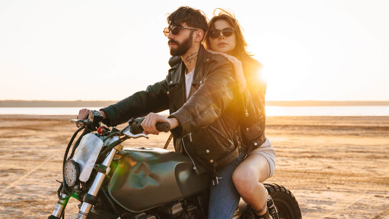 Things Husbands Don't Realize They Do To Make Their Wives Feel Unloved husband and wife riding motorcycle on the beach looking off into the distance