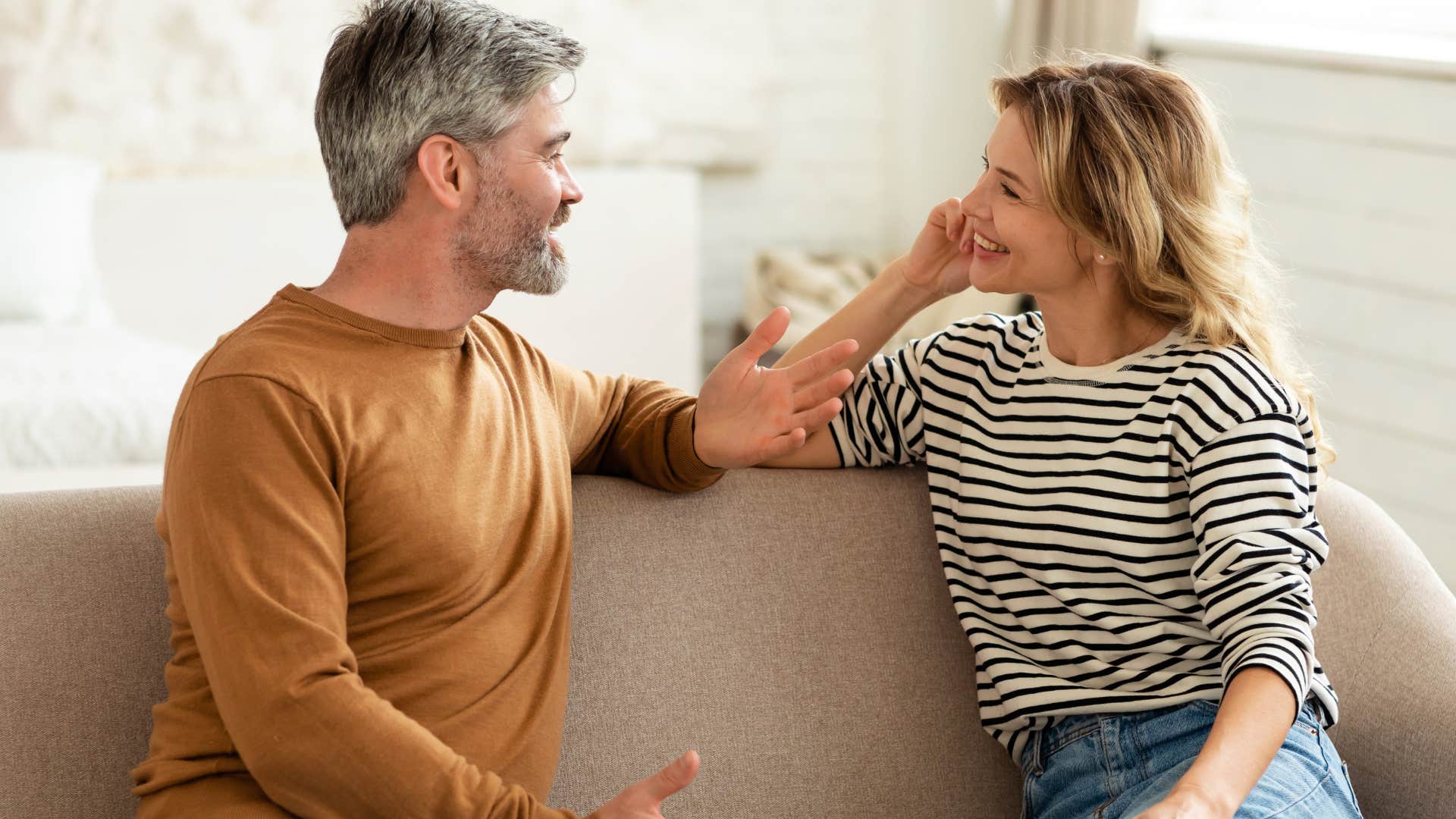 Couple smiling and talking together on the couch