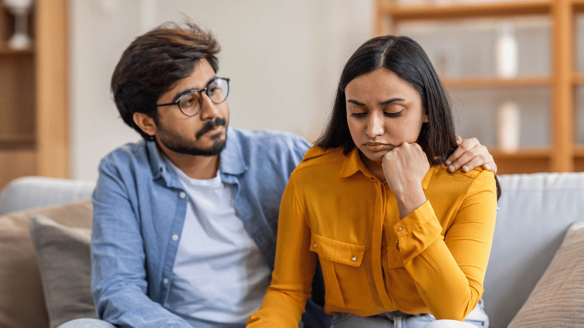 Husband puts arm around wife and listens