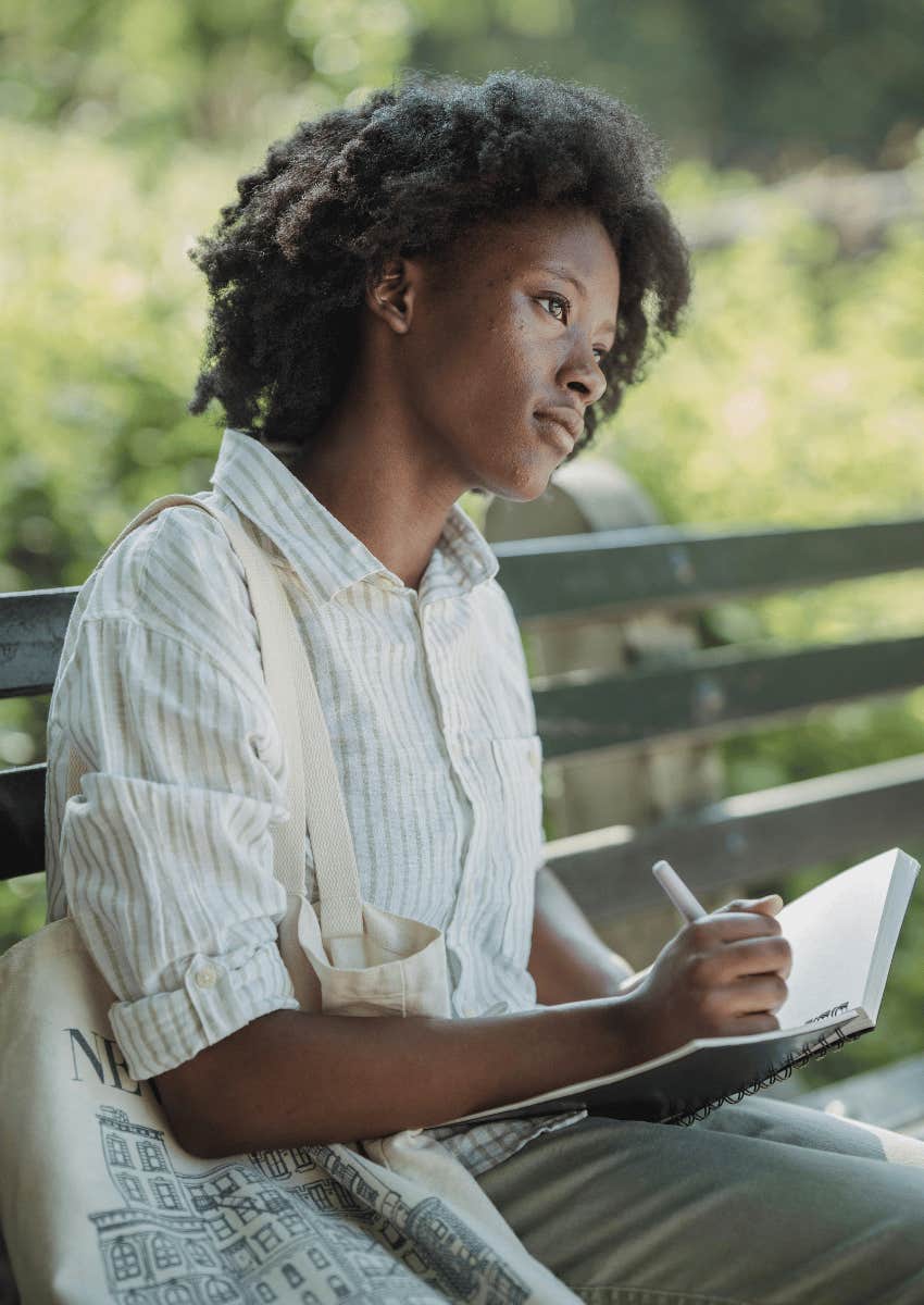 woman sitting outdoors and journaling