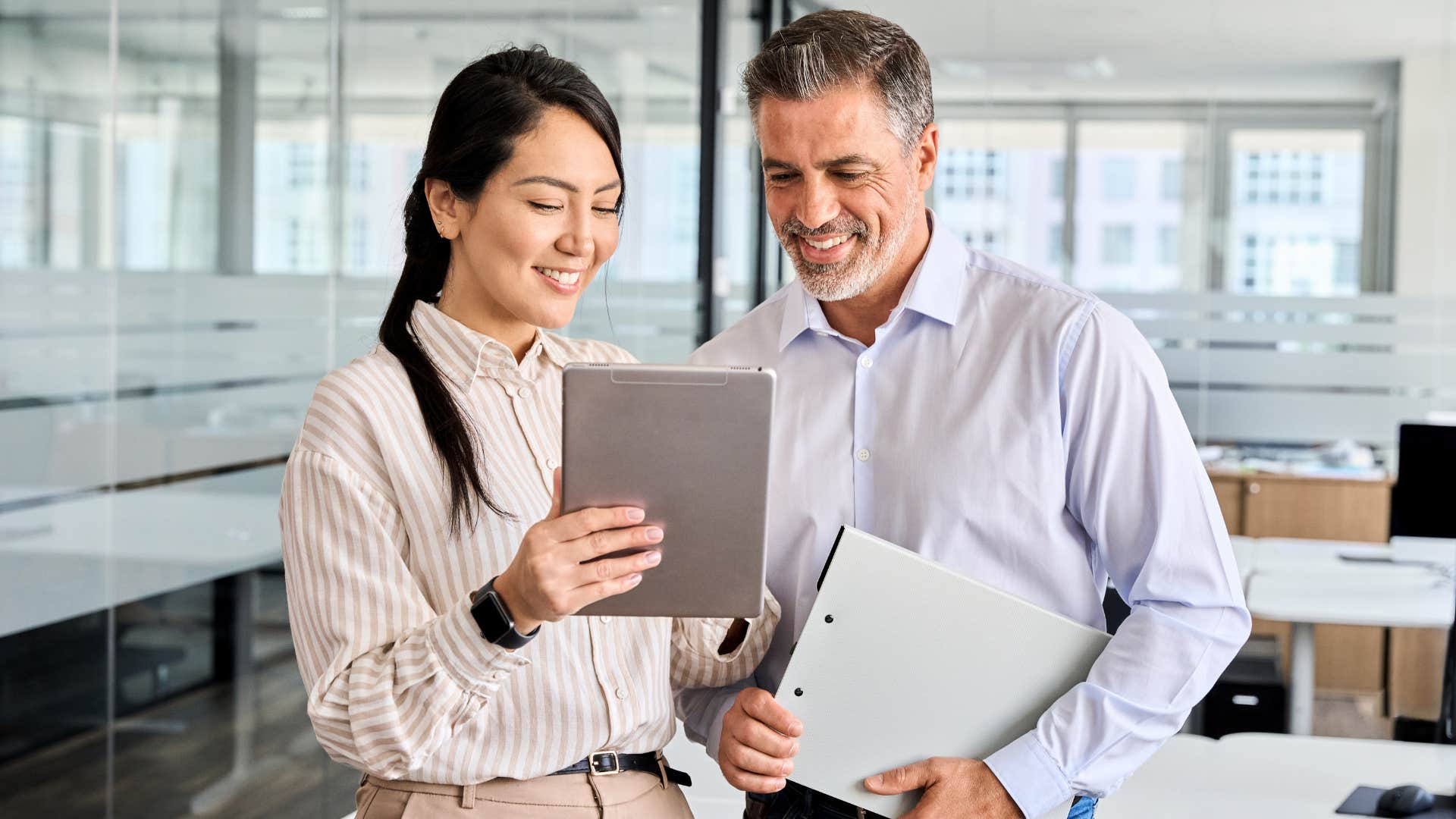 Co-workers talking and looking at a tablet together