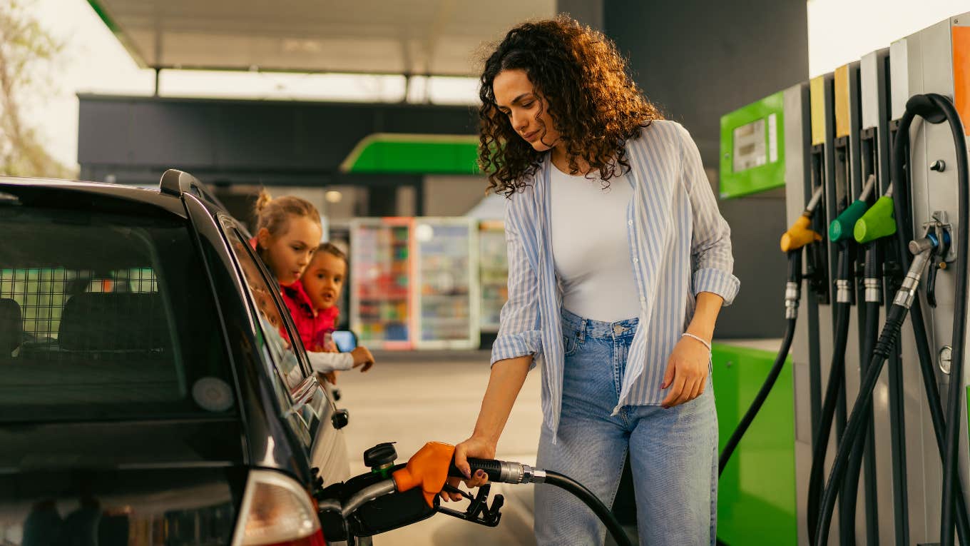 Woman with kids in the car pumping gas