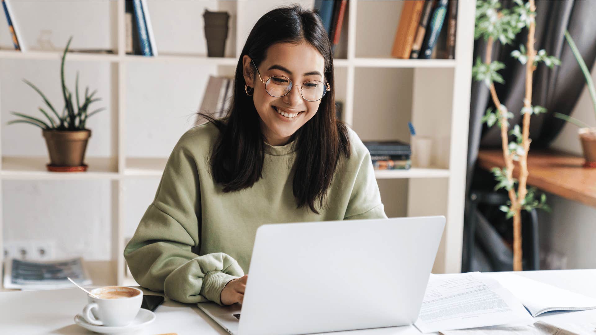 woman typing on laptop while smiling 
