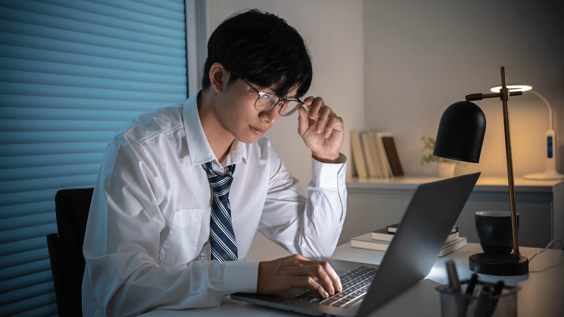 man focused while looking at laptop