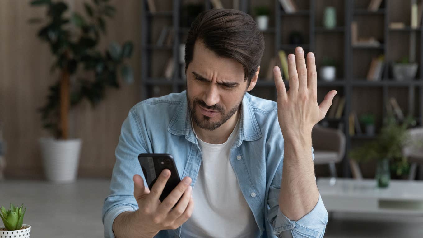 Man Angry That The Government Banned An App But Did Not Protect Schoolchildren man looking at his phone angry and frowning