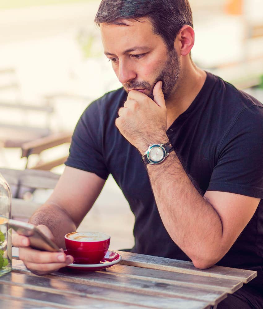 man scrolling LinkedIn at a coffee shop