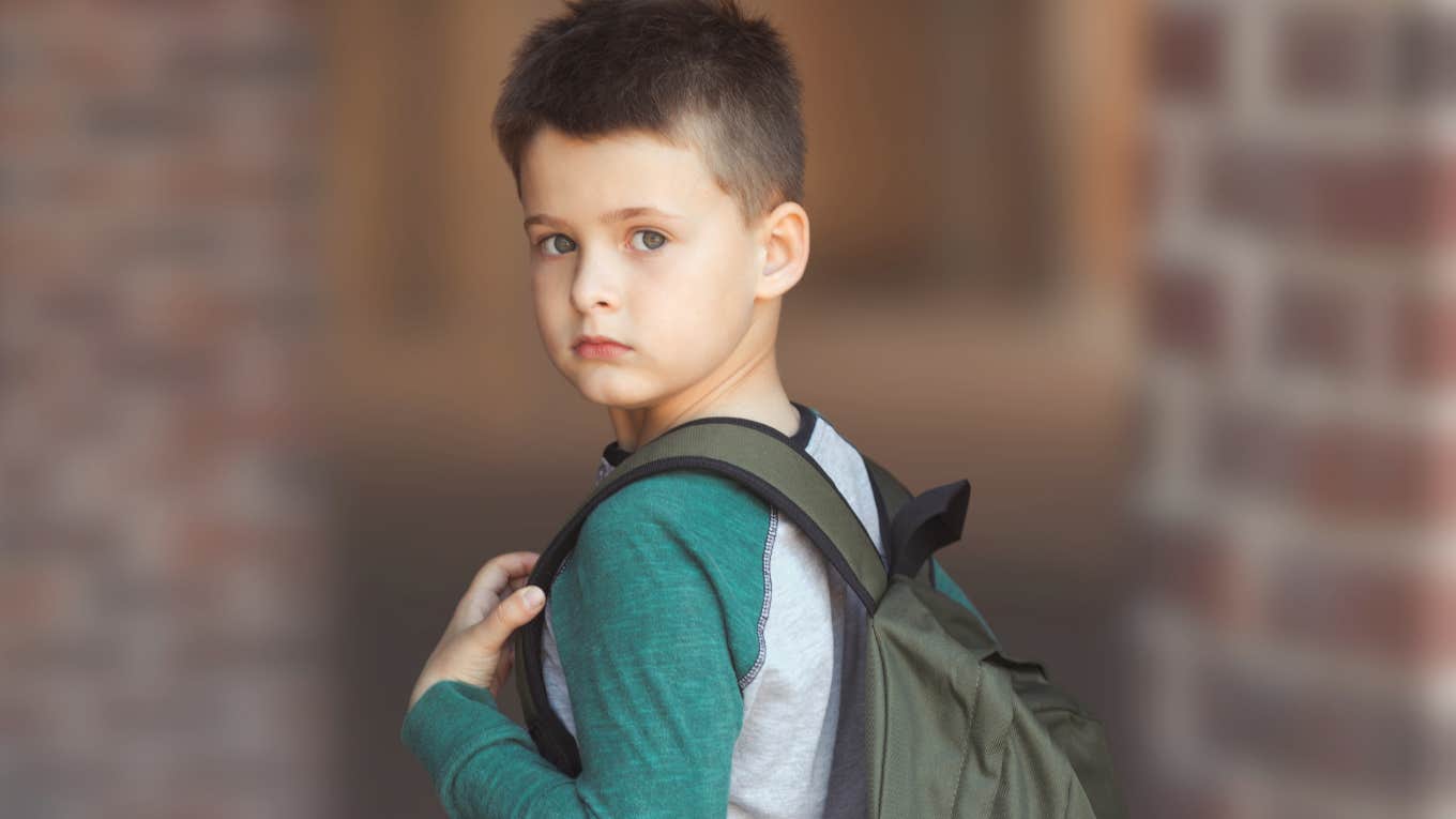 Old-Fashioned Lessons Brilliant Parents Still Teach Their Kids Young boy with a backpack standing in front of his school.