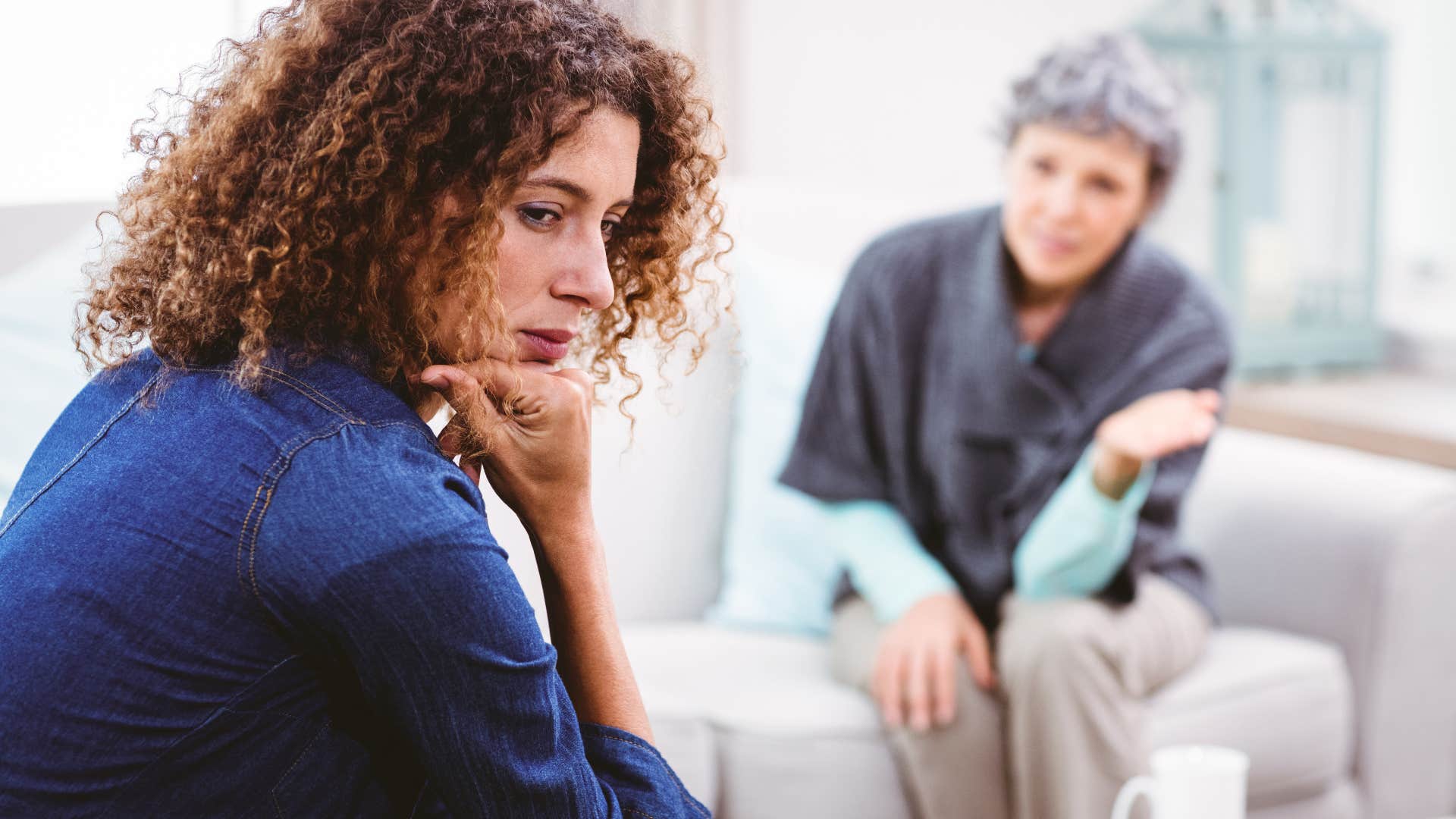 Upset adult woman turned away from her mother.