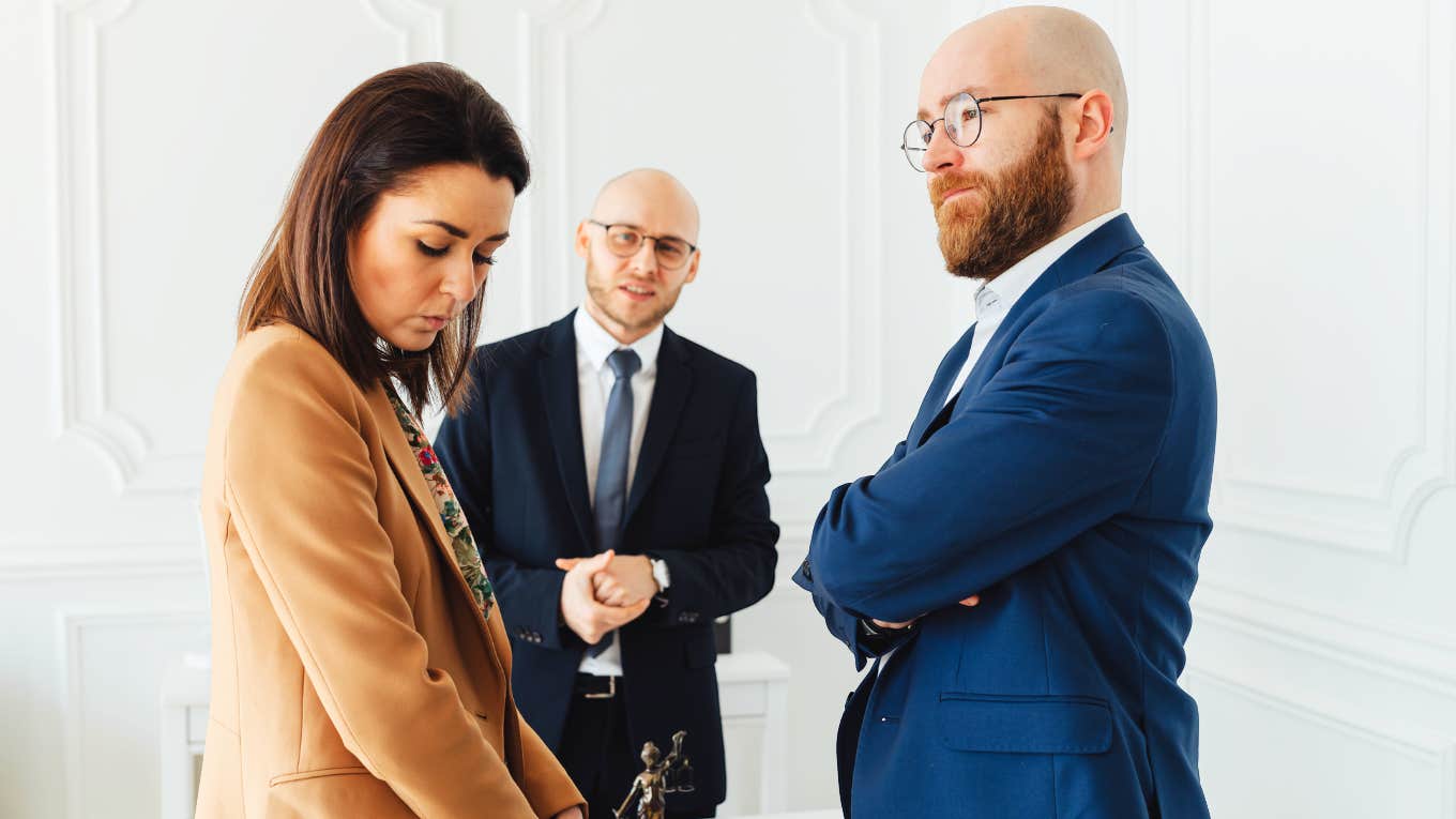 The Stupefying Reason Your Ex Turned Into A Complete Monster After Divorce Woman looking down feeling anger, while husband looks satisfied.