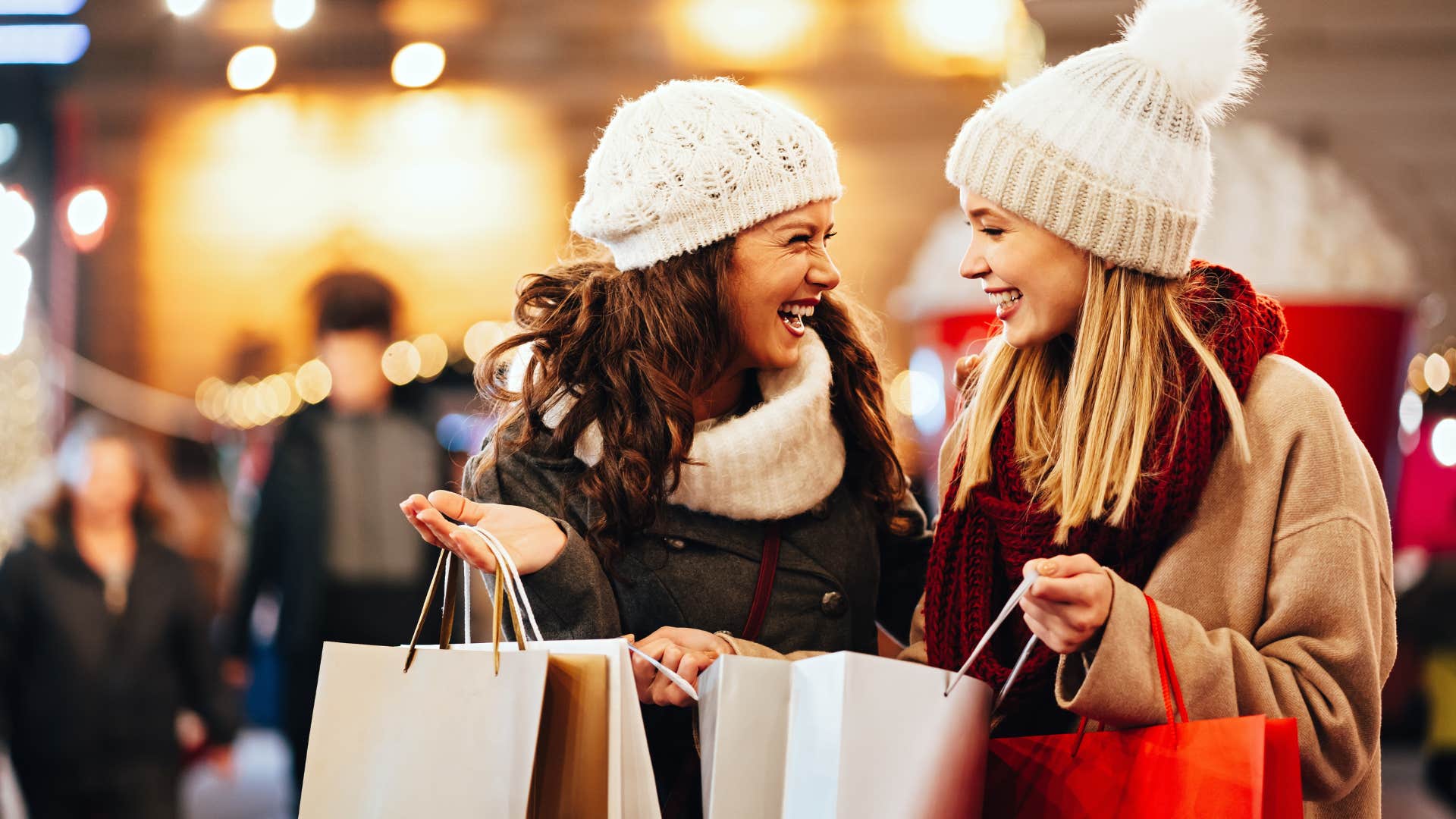 Two women doing their holiday shopping smiling.
