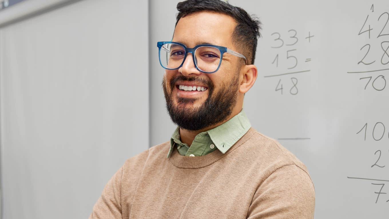 Things Gen Z Kids Were Taught In School That Would Make Boomers Roll Their Eyes Young male teacher smiling in front of his classroom