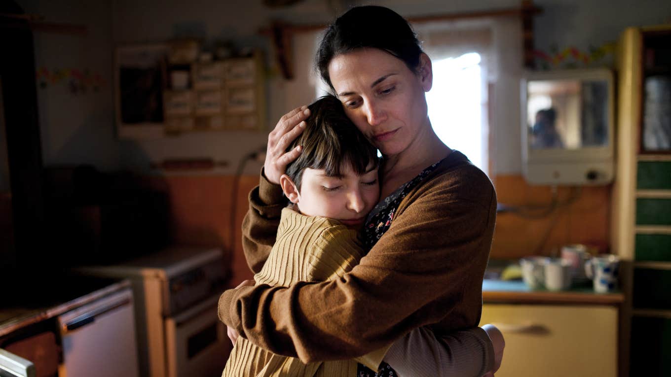 Things Parents Should Never Discuss In Front Of Their Kids, According To Psychology Portrait of sad mother hugging small daughter indoors at home