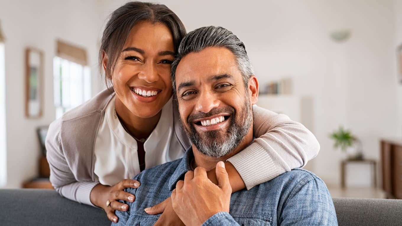 Traits Of A Man Who Will Become An Excellent Provider As A Husband couple smiling together sitting on couch