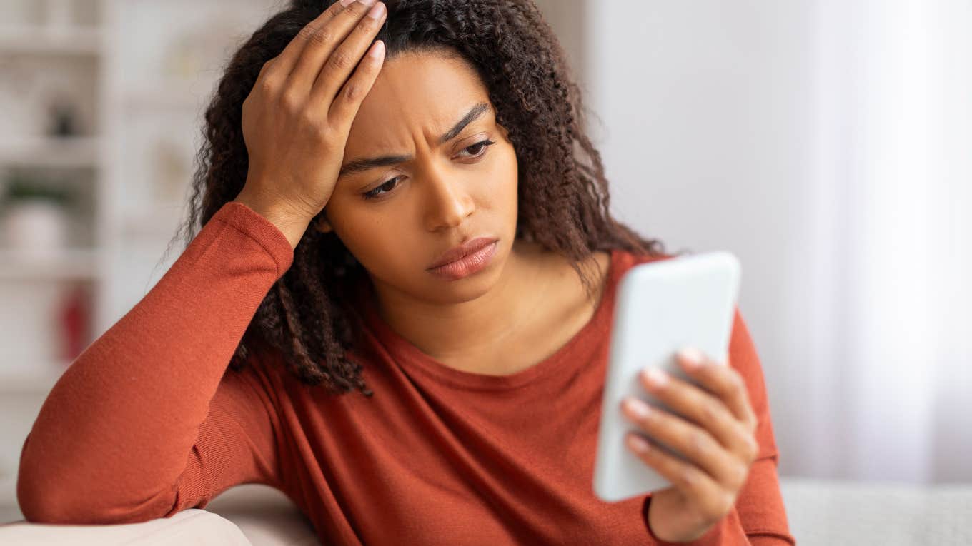 Why People Are So Disturbed By The Economist’s World Ahead Cover Concerned woman looking at the Economist’s 2025 World Ahead cover on her phone