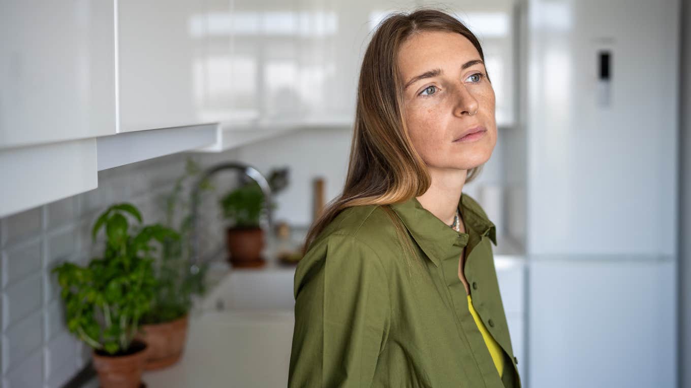 Woman Was Extremely Uncomfortable After Airbnb Host Invaded Her Privacy To Turn Off A Fan Pensive thoughtful woman with distressed mood stands in kitchen of home