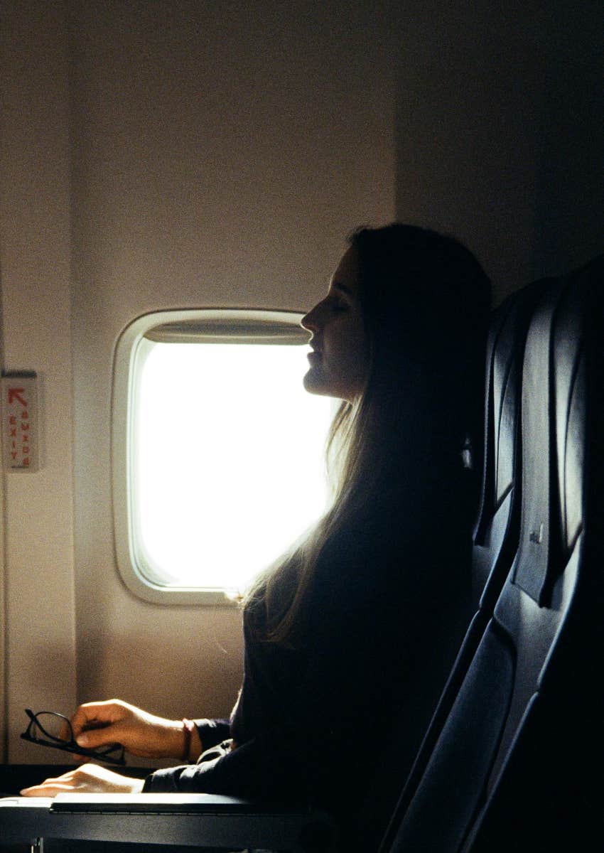 woman sitting in window seat on a plane