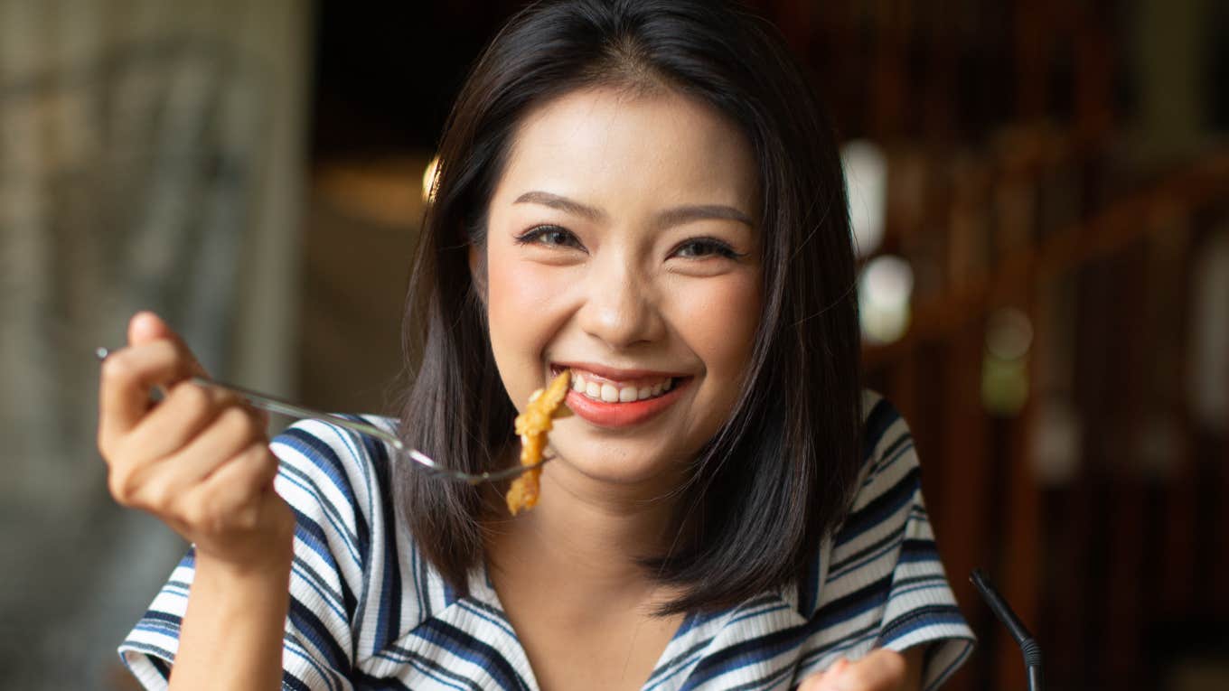 The best Foods To Make You Happy, According To Research Woman eats food to make her happy.