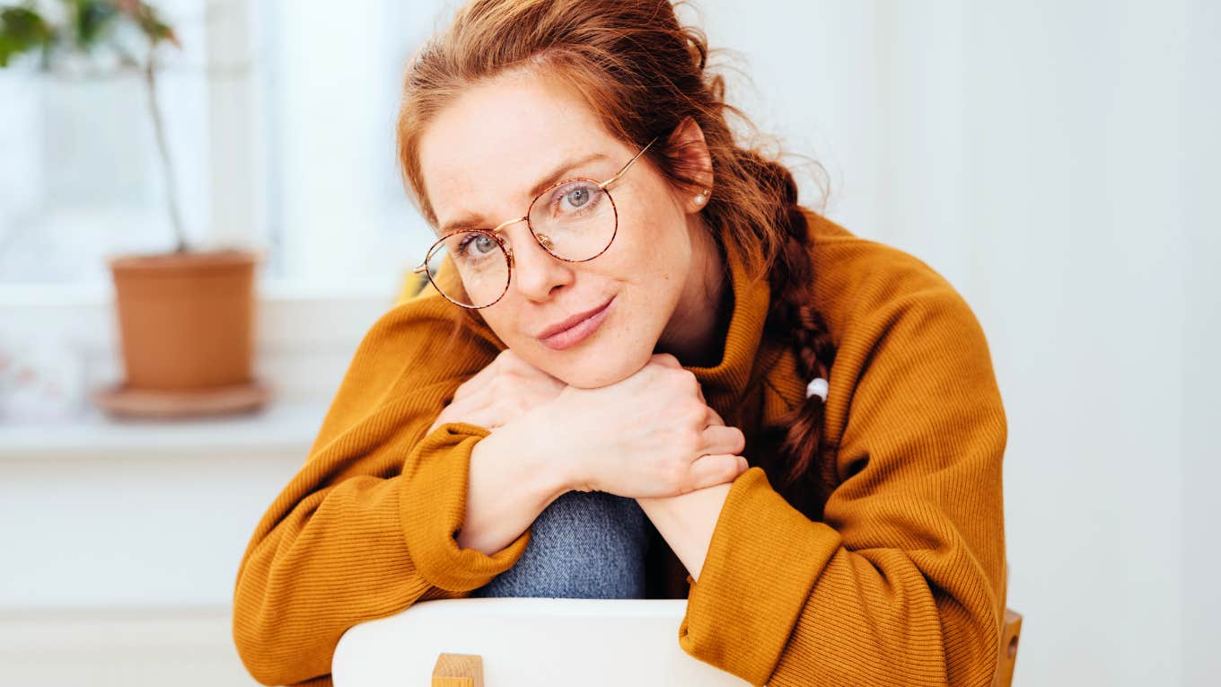 Reasons Being An Introvert Is A True Gift To Modern-Day Society, According To Psychology Introvert woman sitting on chair at home, perfectly content.