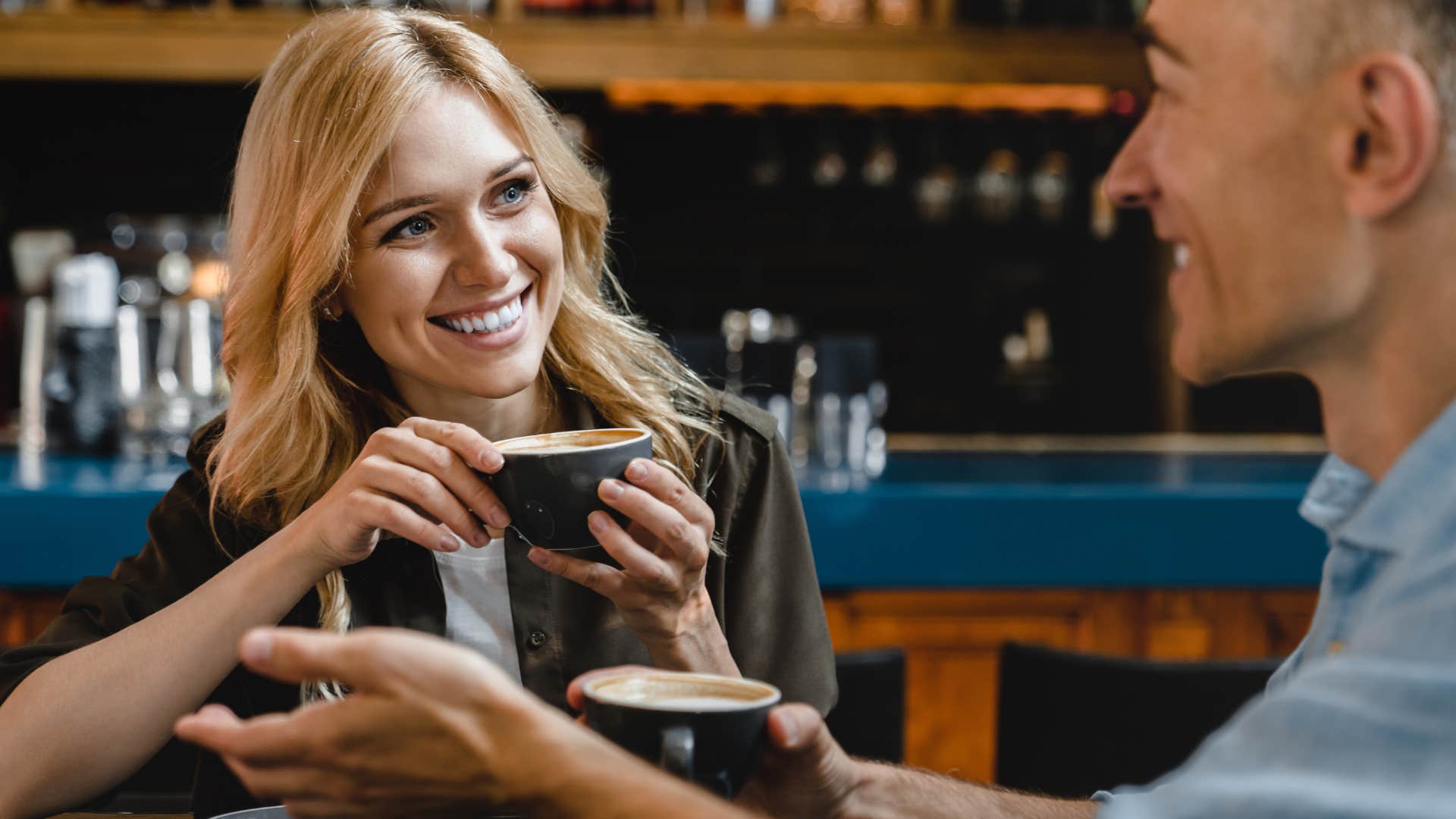 Woman smiling at a man in a coffee shop