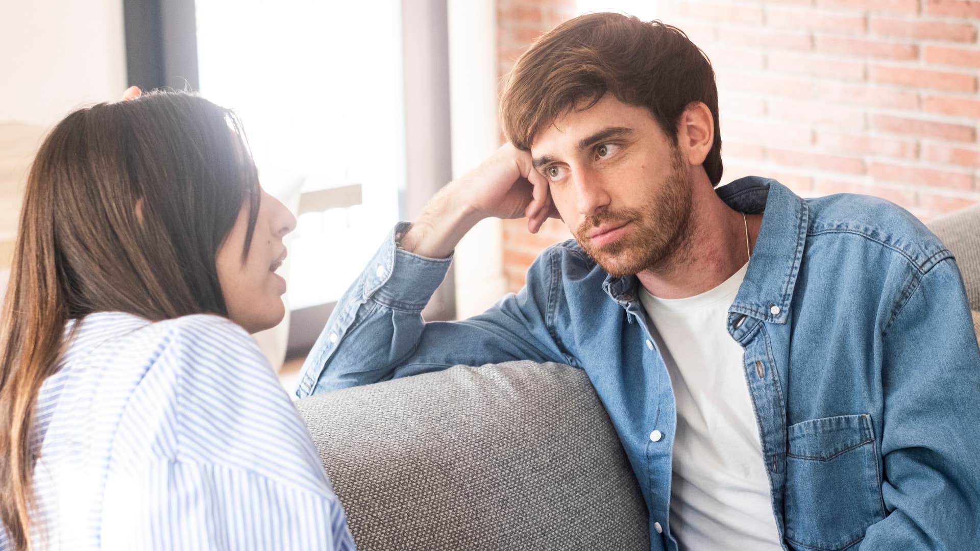 Man having a serious conversation with his partner on a couch