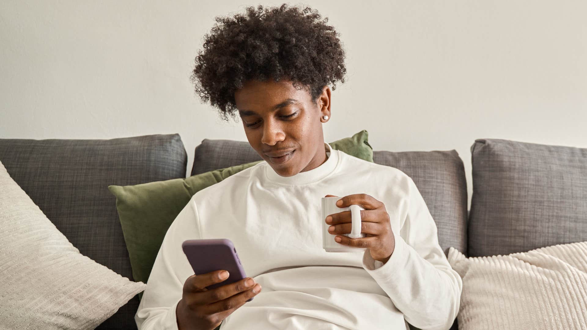 man sitting scrolling on their phone