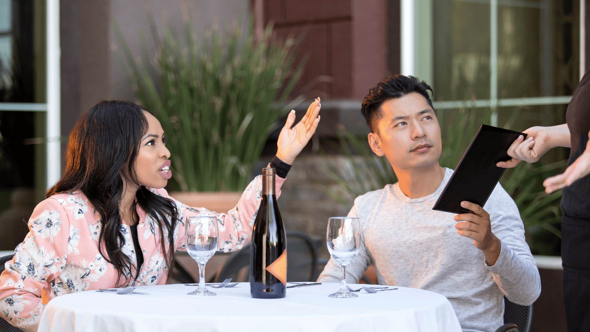 Couple on a date angry at a waitress in an outdoor restaurant