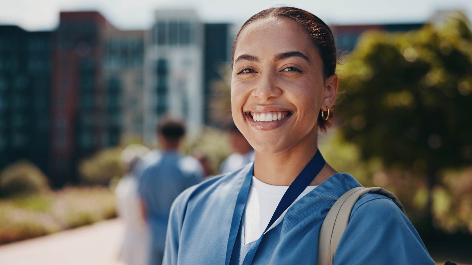 Woman in scrubs smiling at the camera
