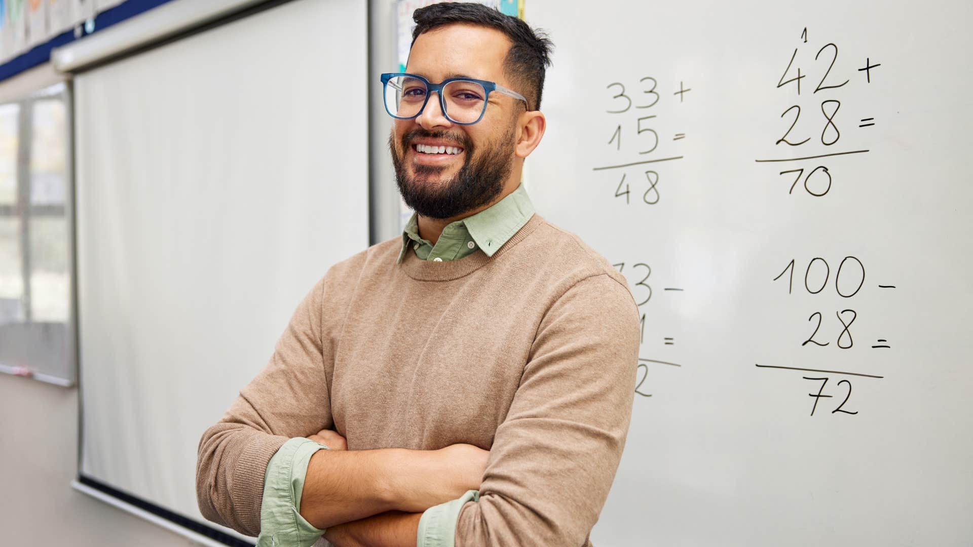 Man smiling at the front of a classroom