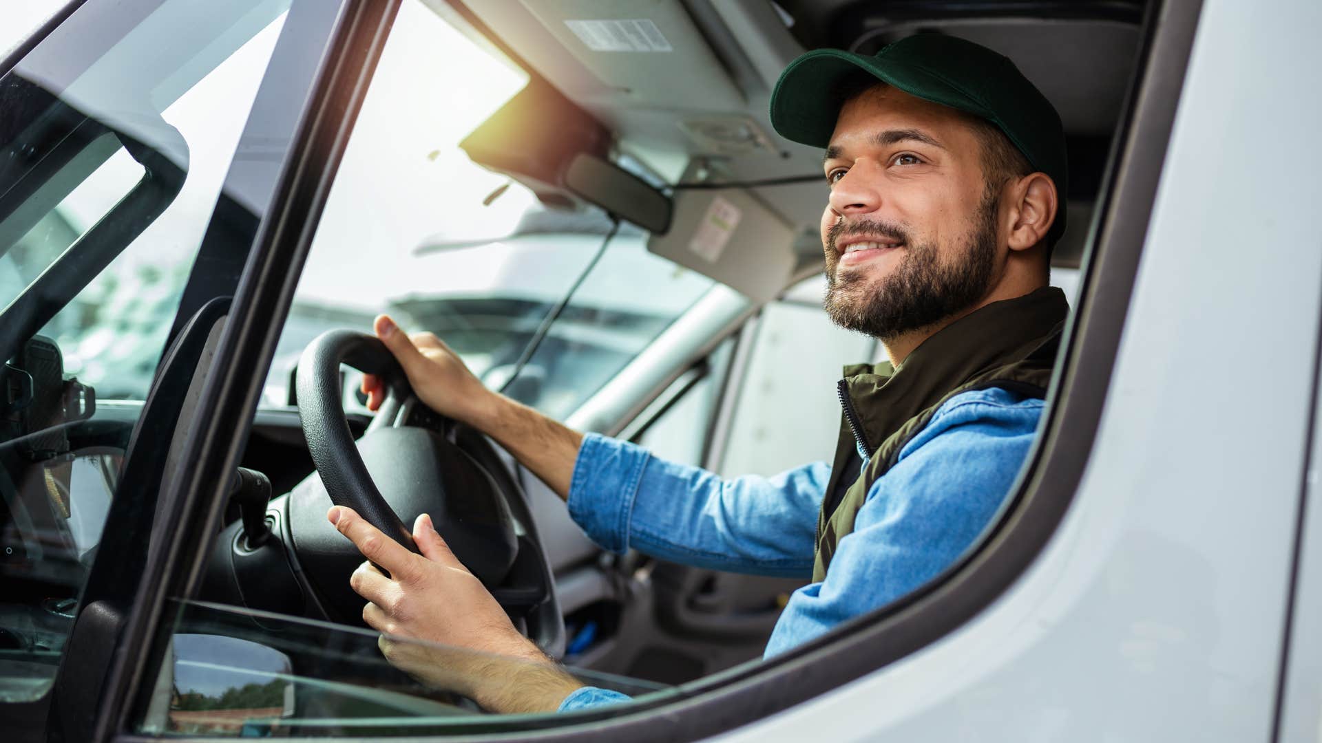 Man smiling while driving a semi-truck