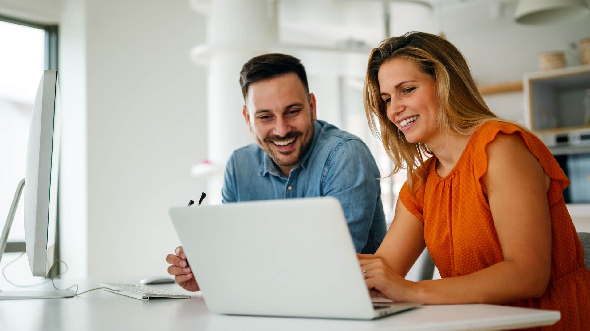 man admiring his wife's work on her laptop
