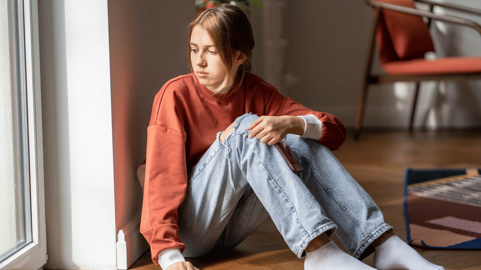 sad young woman looking out the window