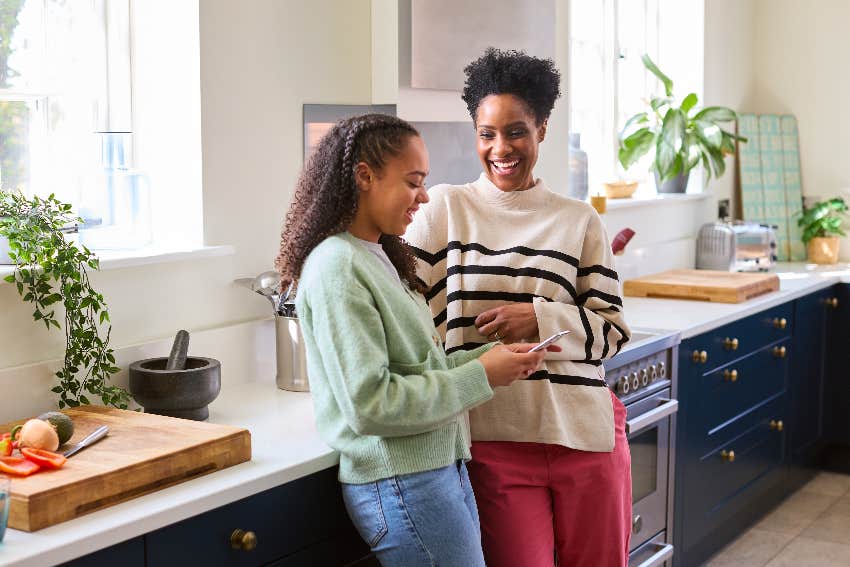 parent and teen daughter talking in kitchen
