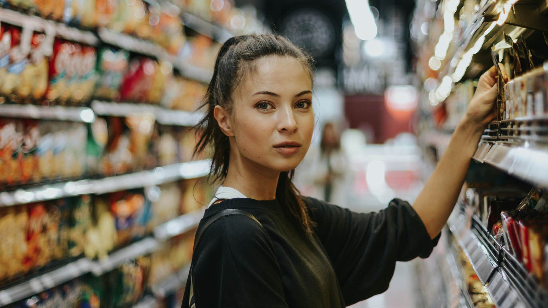 woman looking ahead in grocery store aisle