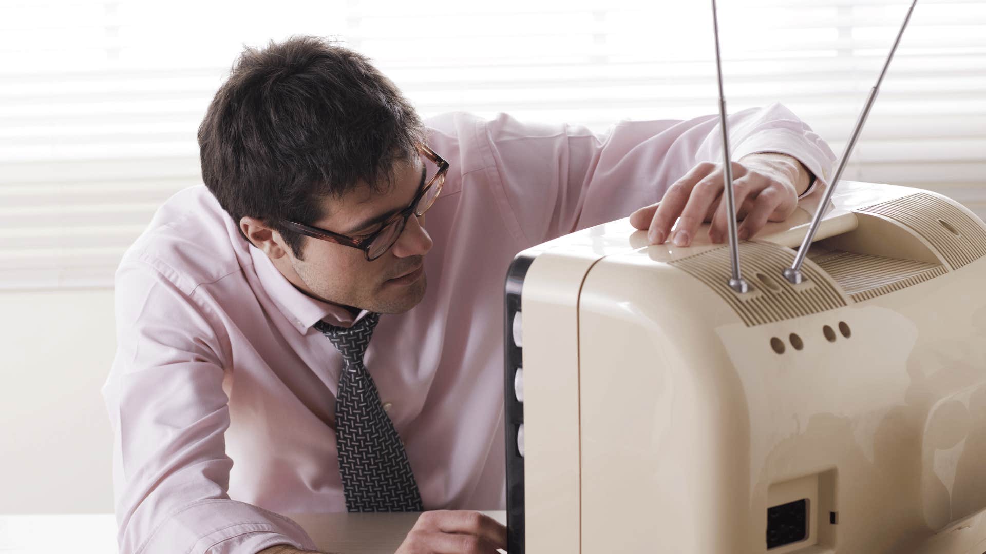 man adjusting antique tv