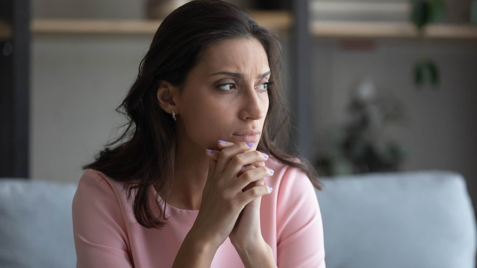 sad woman sitting on her couch