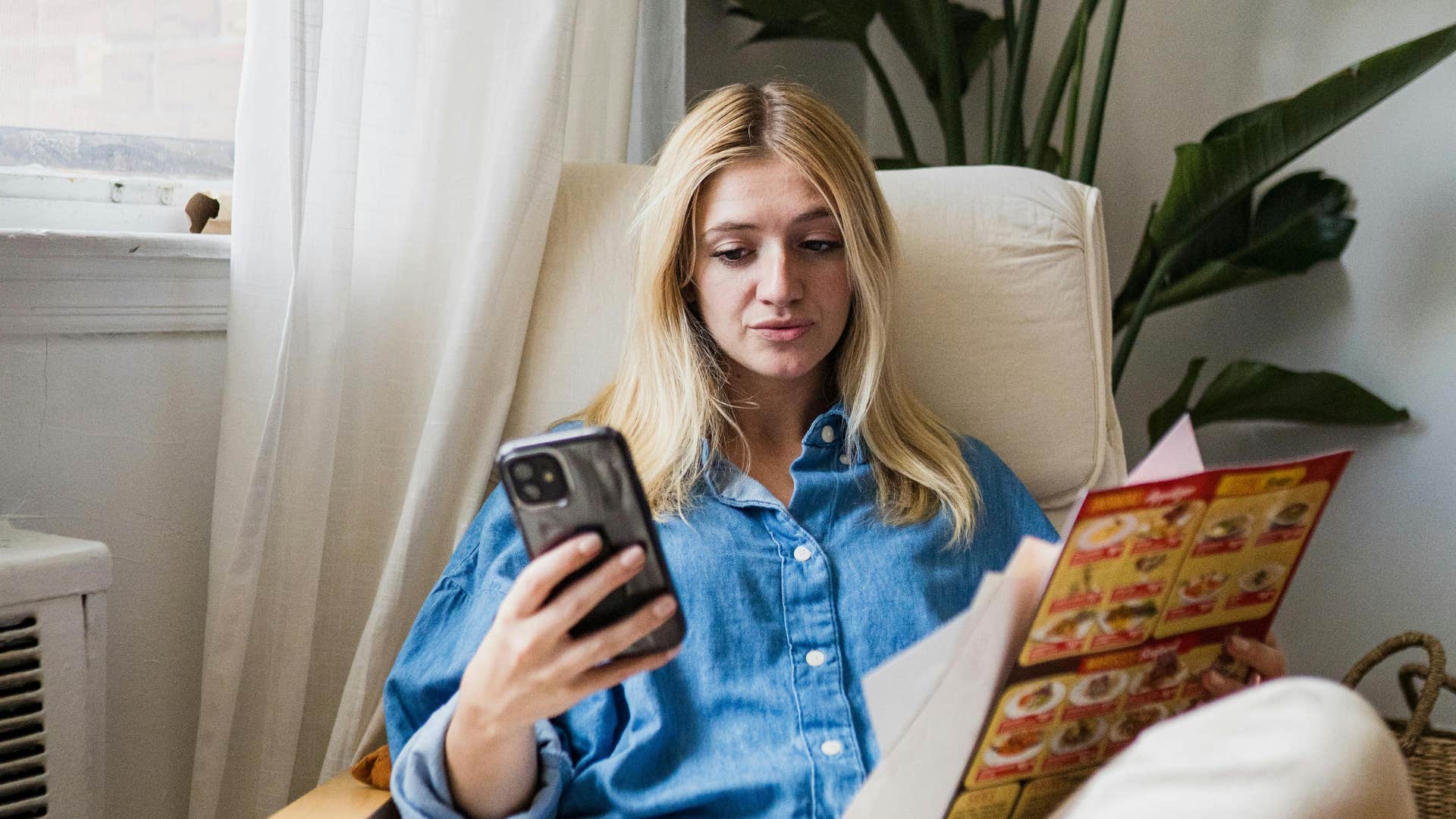 young woman looking at a takeout menu