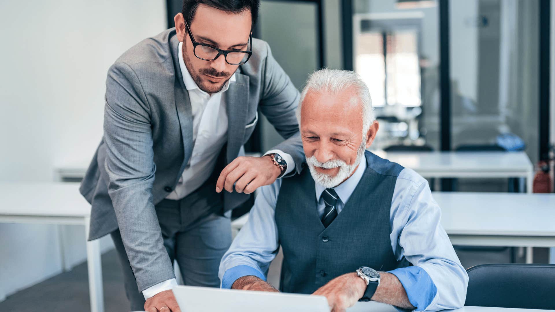 boomer man happy to be working hard with younger man