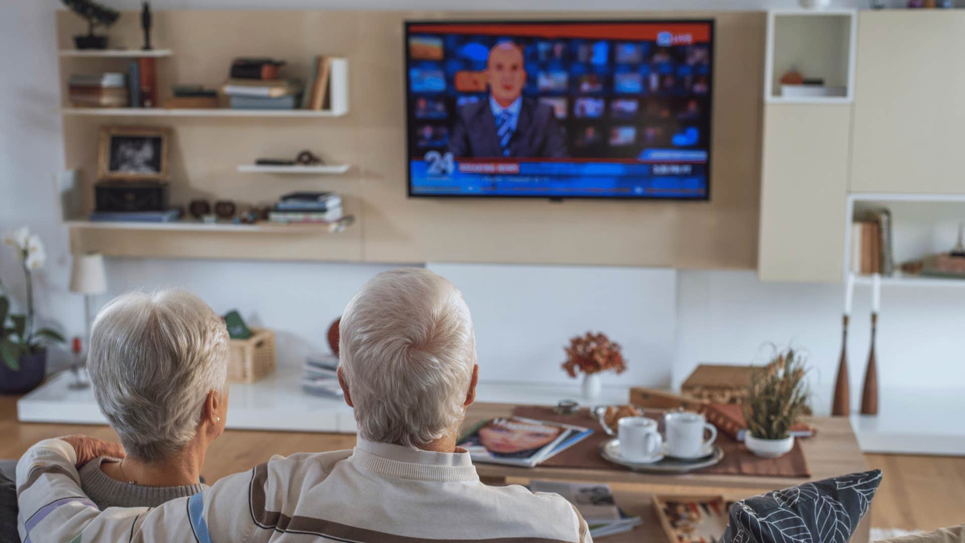 boomer couple watching news on TV