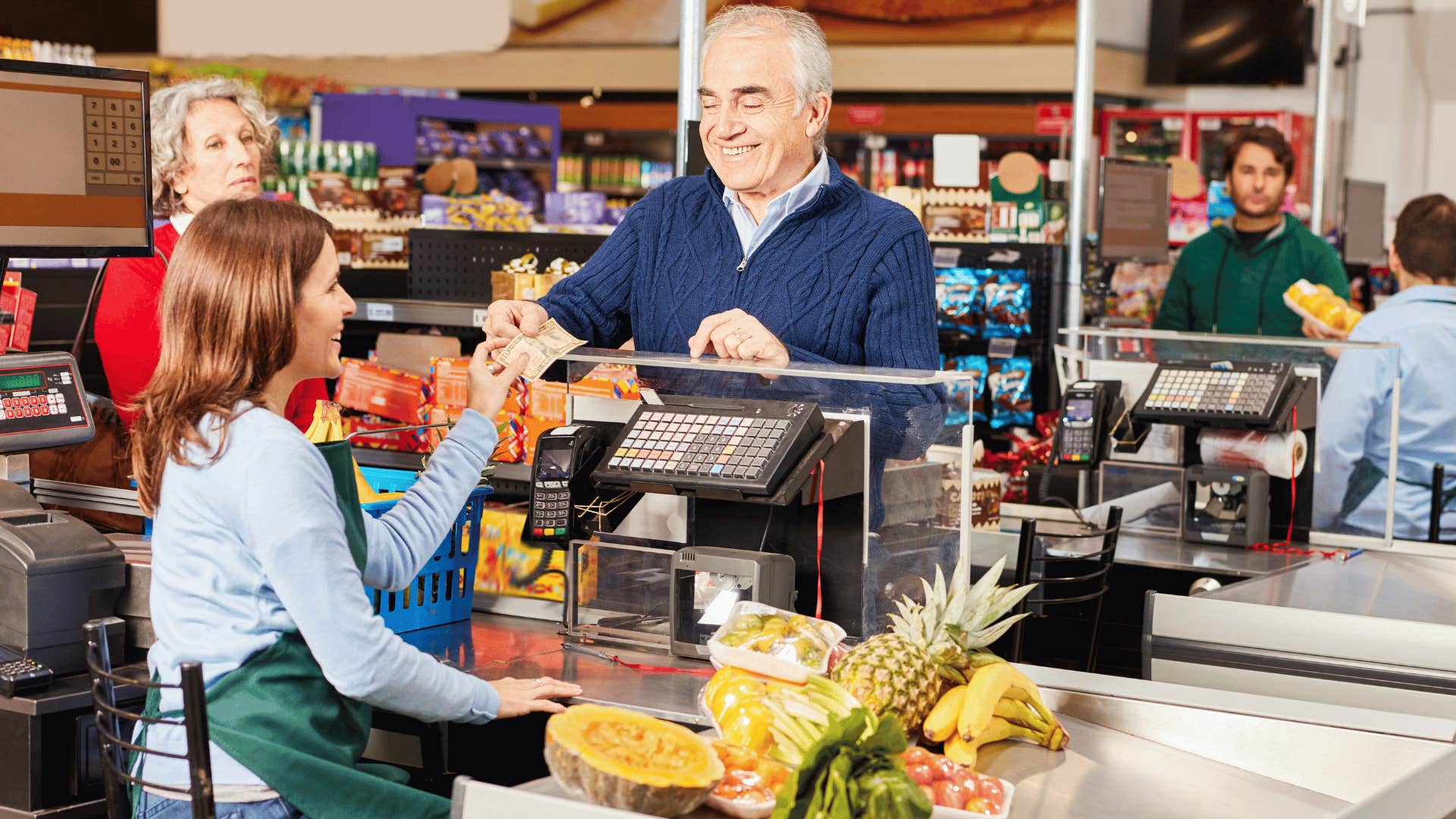 boomer man paying for groceries with cash