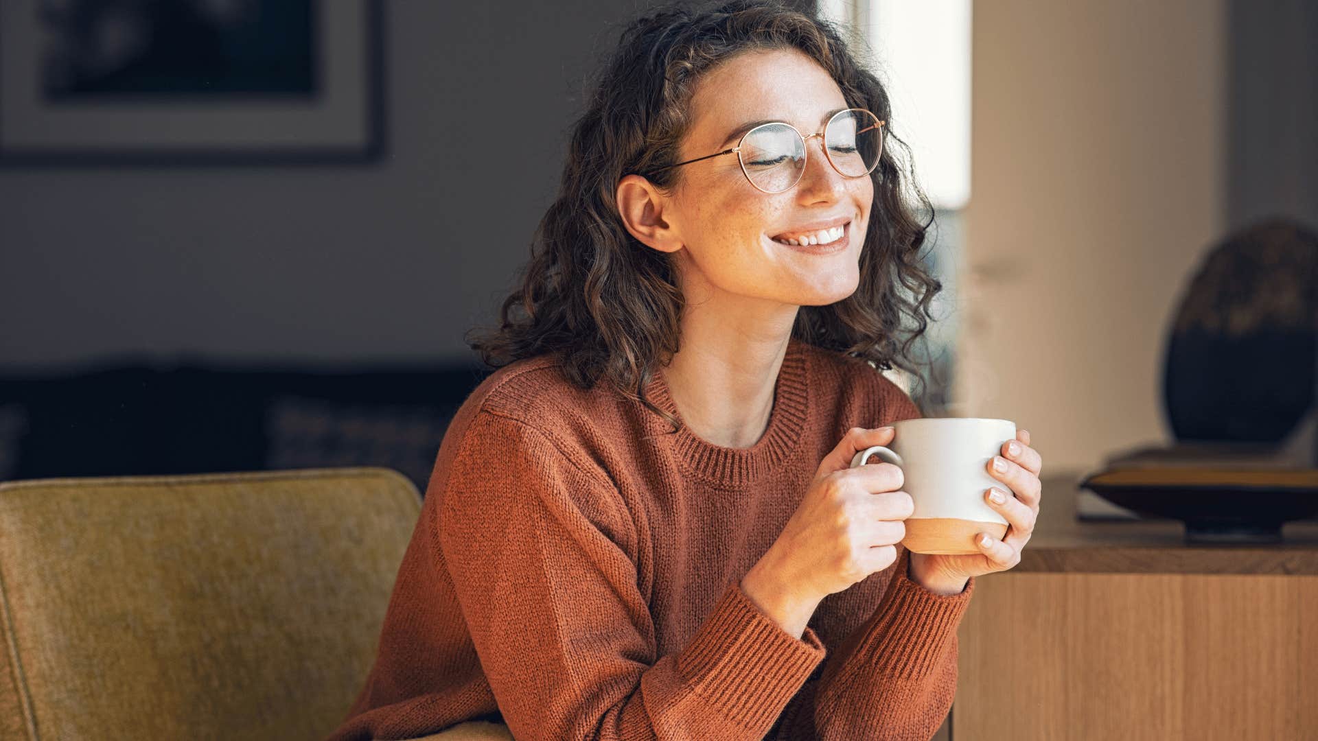 peaceful woman smiling while drinking coffee