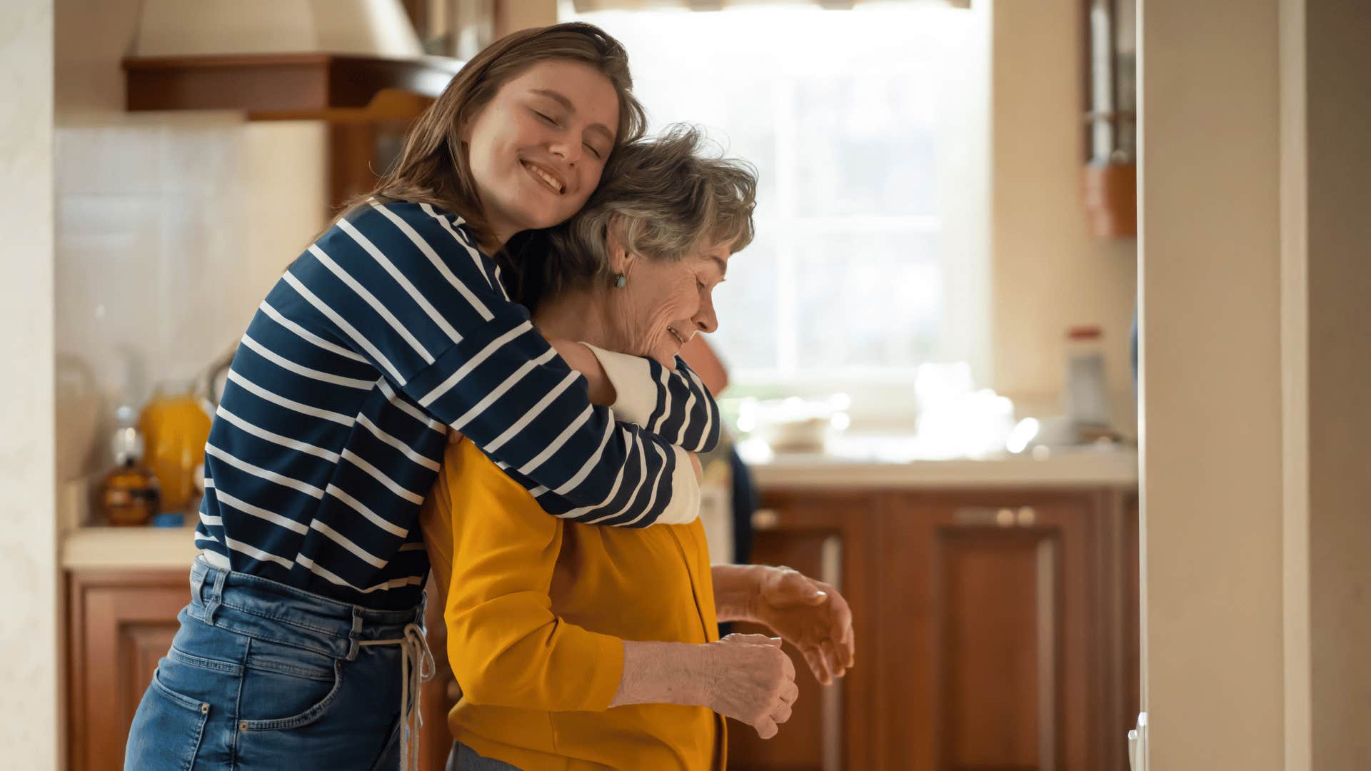 compassionate woman hugging older mother