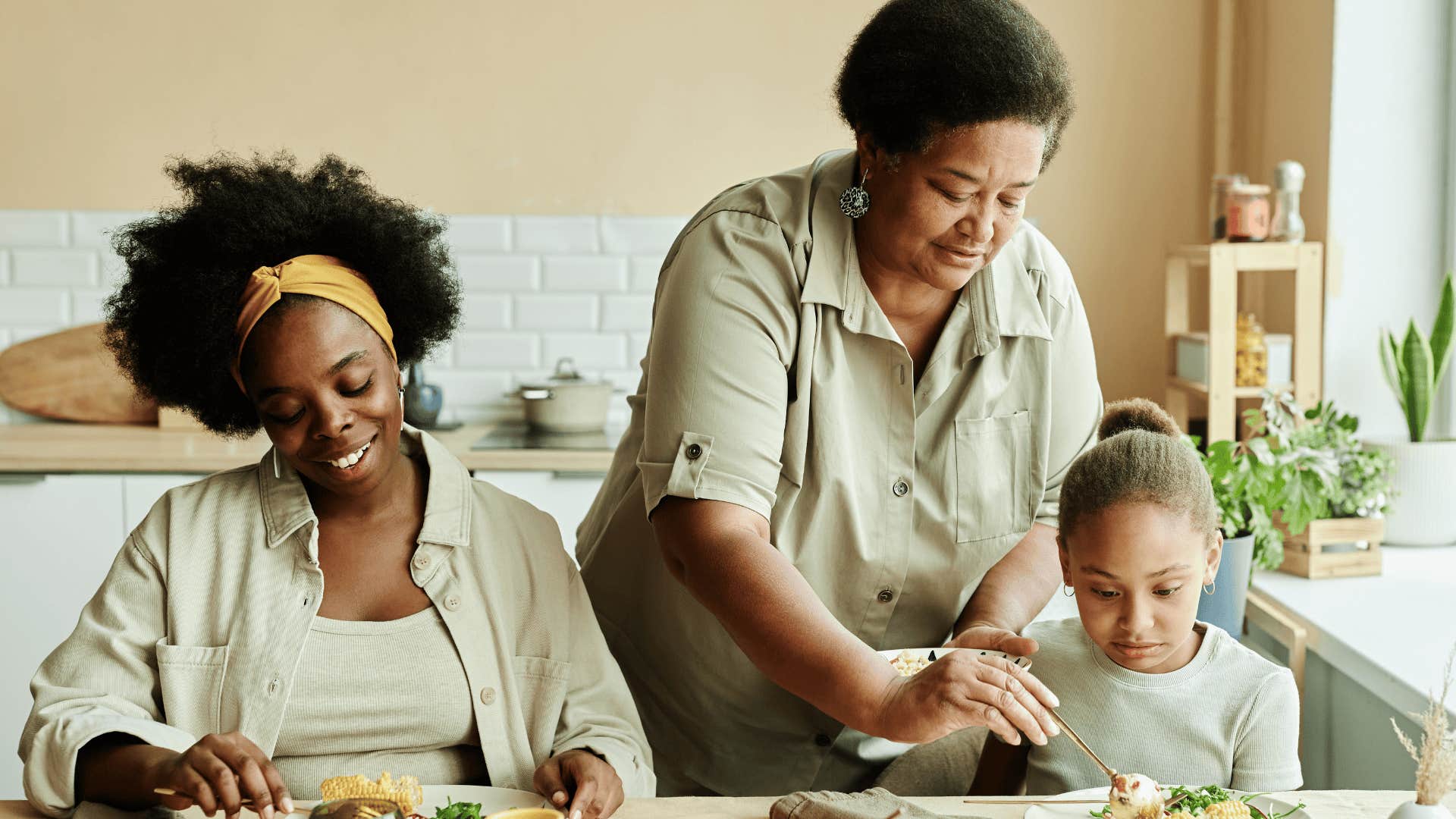 older woman serving food to daughter and granddaughter 