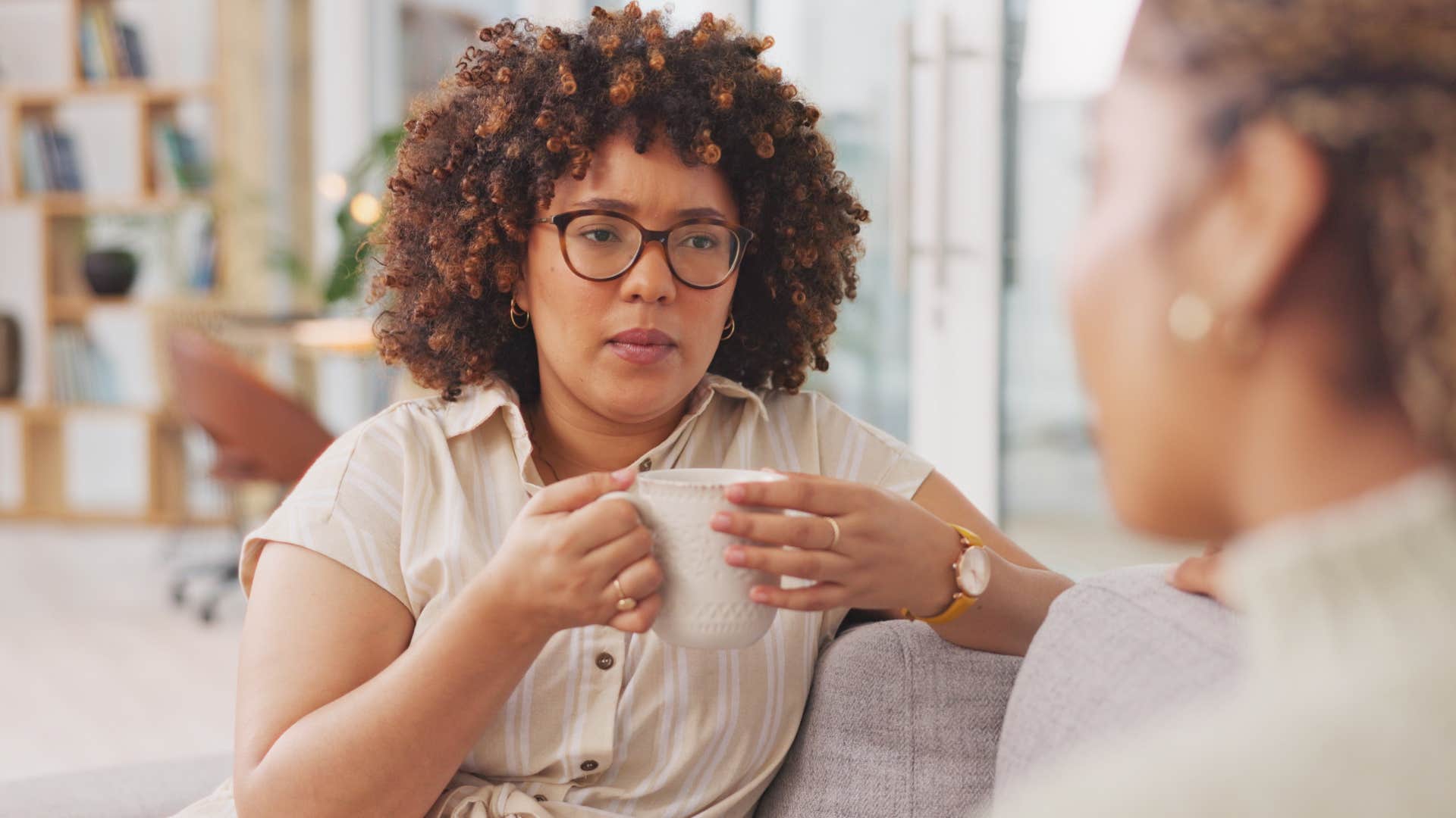 Serious woman listening to her friend talk honestly 