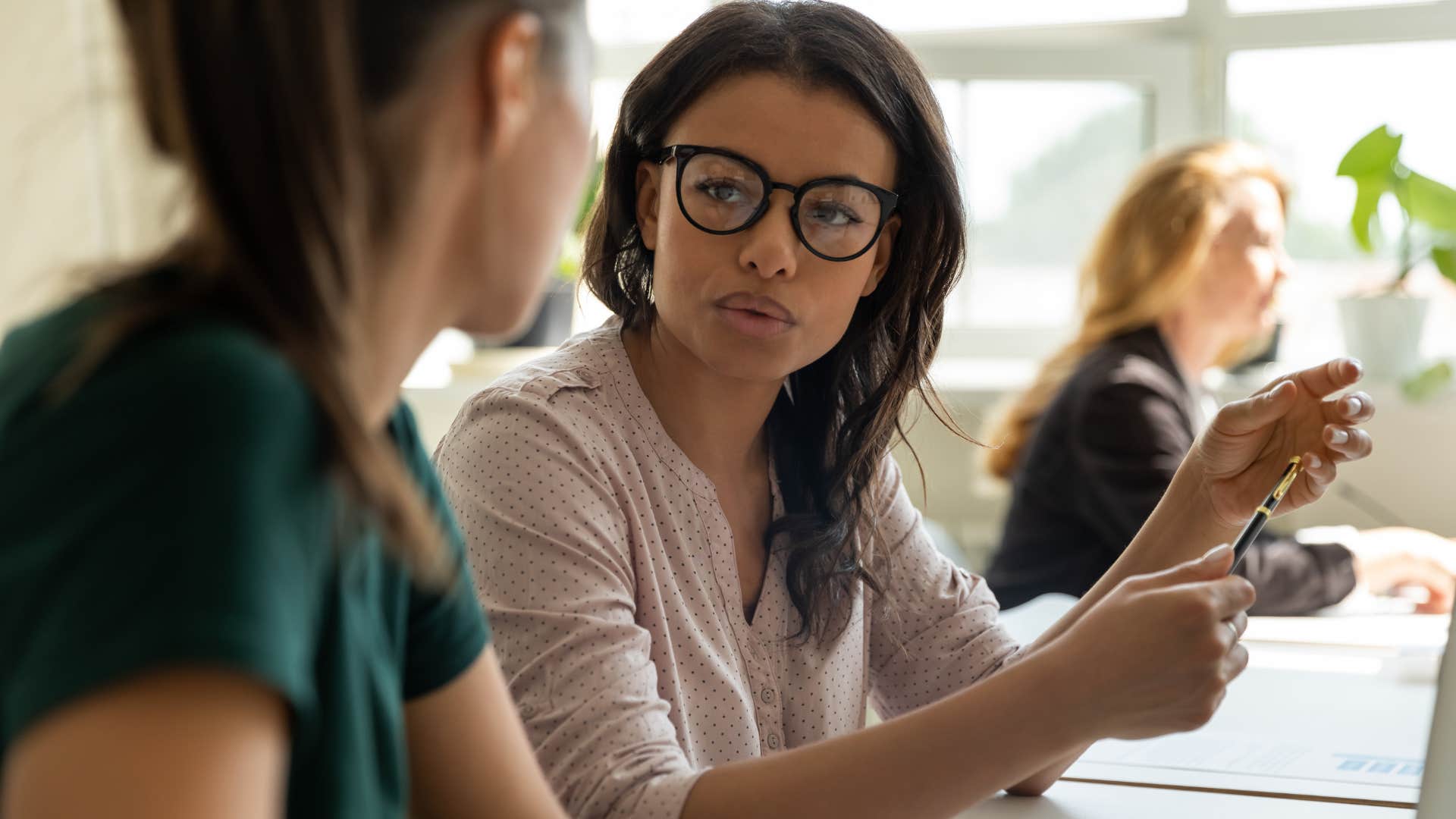 Upset woman talking to her friend at work saying she has a dumb question