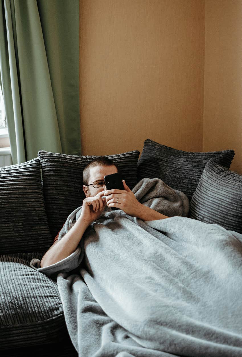 Man lying on the couch thinking apathy is cool but it's just rude